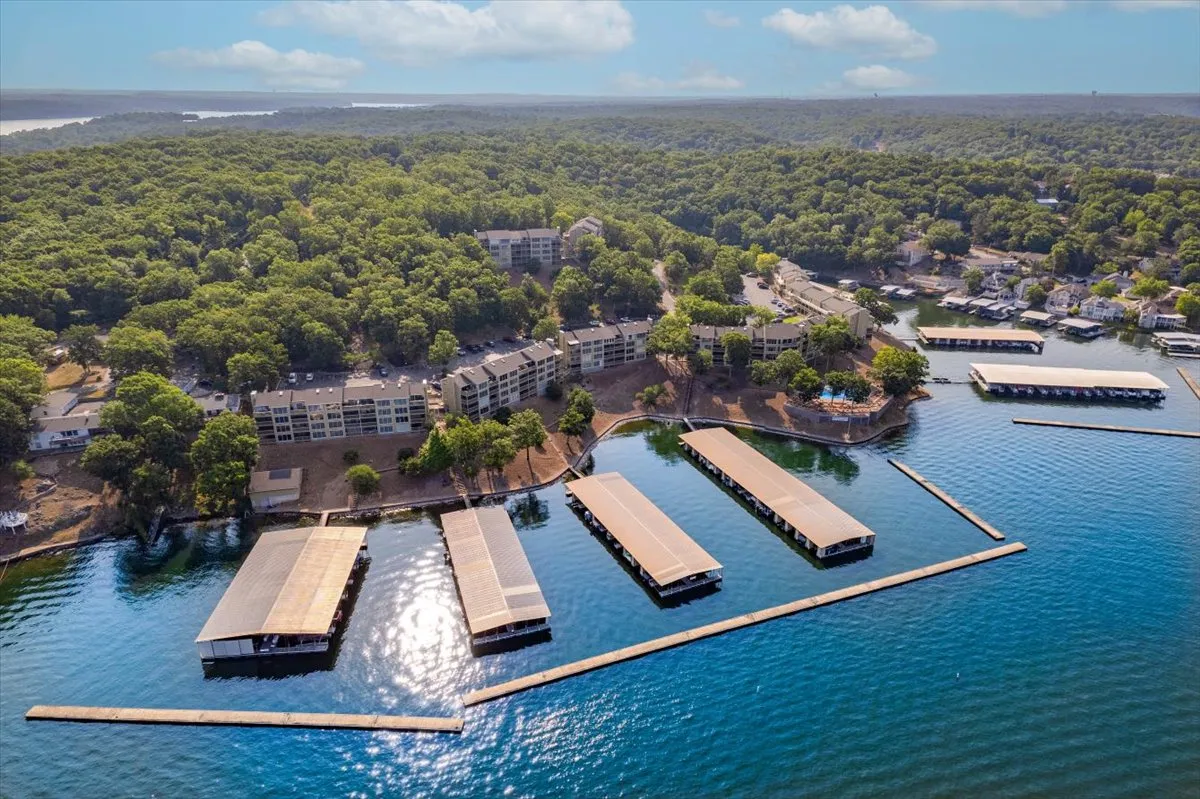 The marina docks stretch out over a peaceful body of water, surrounded by trees and residential buildings. The scene is set for boating, fishing, or simply enjoying a quiet walk along the docks while soaking in the lakeside ambiance.